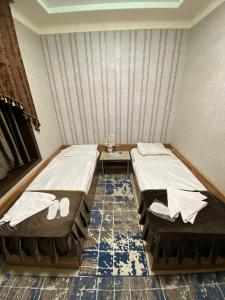 ein Schlafzimmer mit 2 Betten und einem Tisch darin in der Unterkunft Davan LUX in Taschkent