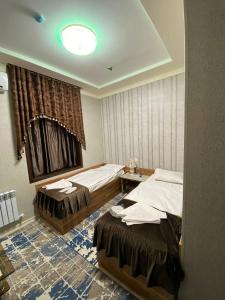 a hotel room with two beds and a window at Davan LUX in Tashkent
