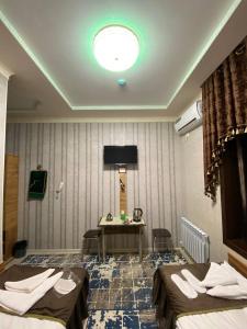um quarto de hotel com duas camas e uma televisão em Davan LUX em Tashkent