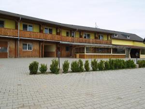 a building with a courtyard with trees in front of it at Pension u Vlčků in Hracholusky