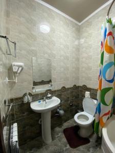 ein Bad mit einem WC und einem Waschbecken in der Unterkunft Davan LUX in Taschkent