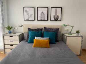 a bedroom with a bed with blue and yellow pillows at Habitación en casa de Mikel in Olite