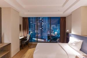 a hotel room with a bed and a view of a city at ARECA HOTEL NHA TRANG in Nha Trang