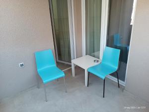 two blue chairs and a white table in a room at Grand Apartments Strumica in Strumica