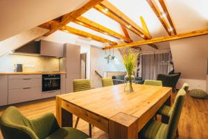 a kitchen and dining room with a wooden table and chairs at Penzion Tilia in Český Krumlov