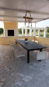 un patio con grande tavolo e sedie in legno di Casa Loredana a Putignano