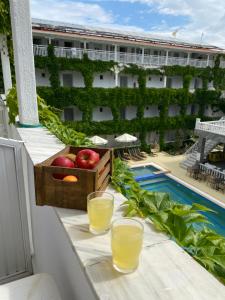 a balcony with a basket of apples and two glasses of orange juice at Olympic Kosma Hotel & Villas - Hanioti in Hanioti