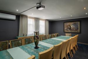 a dining room with a long table and chairs at Isijula Boutique Hotel in Westonaria