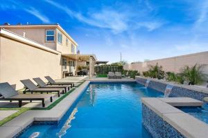 uma piscina com cadeiras e uma casa em Modern Luxury Home w/ Private Pool & Spa 2.0 em Indio