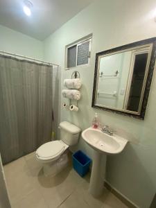 y baño con aseo, lavabo y espejo. en Casa Gn 37 Excellent Location North of the city Guaymas Sonora, en Guaymas