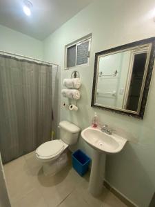 a bathroom with a toilet and a sink and a mirror at Excellent Location North of the city Guaymas Sonora in Guaymas