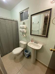 een badkamer met een toilet, een wastafel en een spiegel bij Casa Gn 37 Excellent Location North of the city Guaymas Sonora in Guaymas
