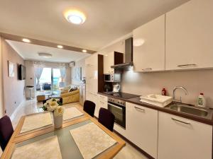a kitchen and dining room with a table and chairs at Apartmani Jasminka in Dramalj