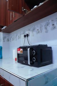 un four micro-ondes installé sur un comptoir dans une cuisine dans l'établissement Bamburi 2BR Apartment, à Mombasa