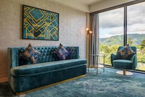 a living room with a couch and a chair at The Sebel Wellington Lower Hutt in Lower Hutt