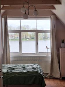a bedroom with a large window with a view of the water at Villa Marienholm in Haapsalu