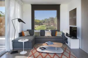 ein Wohnzimmer mit einem Sofa und einem TV in der Unterkunft Villa Partenope in Favignana
