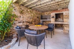 a patio with a table and chairs and a fireplace at Villa Harmony in Supetar