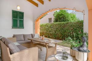 a patio with a table and wicker chairs at Menorca Cristina by Mauter Villas in Cala Blanca