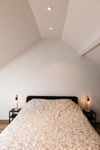 - une chambre avec un lit et deux lampes sur les tables dans l'établissement Le panorama, à Dinant