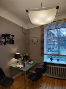 une salle à manger avec une table, des chaises et une horloge dans l'établissement Eksporta 10, LUX, à Riga