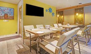 un ristorante con tavoli e sedie e una TV a schermo piatto di Hotel Park N a Vijayawāda