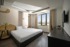 Cette chambre comprend un grand lit et une fenêtre. dans l'établissement Hanami Hotel Danang, à Đà Nẵng