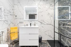a white bathroom with a sink and a mirror at Apolo beach front - sea view luxury apartment in Torrevieja +14 photos