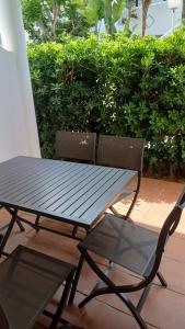 a black picnic table and a chair on a patio at URBANIZACION EL ATARDECER in Novo Sancti Petri