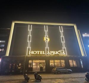 a hotelaria sign on the side of a building at night at Hotel Apricia in Ludhiana