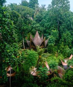 una giungla con un edificio in mezzo a una foresta di Suenyo Eco Retreat a Tabanan