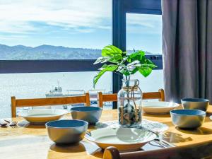 a wooden table with bowls and a vase with a plant at Lavender Homes @ Jesselton Quay Kota Kinabalu in Kota Kinabalu