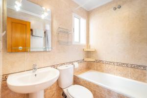 łazienka z toaletą, umywalką i wanną w obiekcie Playa Flamenca Townhouse w mieście Orihuela
