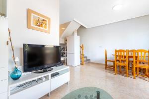 salon z telewizorem z płaskim ekranem na szafce w obiekcie Playa Flamenca Townhouse w mieście Orihuela