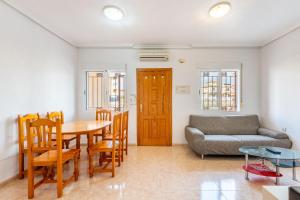 salon z kanapą, stołem i krzesłami w obiekcie Playa Flamenca Townhouse w mieście Orihuela