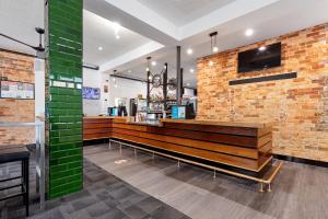 a restaurant with a bench against a brick wall at Pier Hotel Coffs Harbour in Coffs Harbour