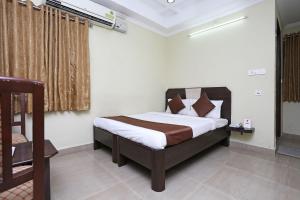 1 dormitorio con 1 cama y 1 silla en una habitación en Hotel Saraswathi Residency Near SR Nagar Metro Station, en Ameerpet