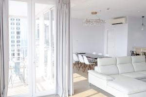 a white living room with a white couch and a table at La Vogue Boutique Hotel & Casino in Sihanoukville