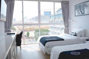 a hotel room with two beds and a large window at La Vogue Boutique Hotel & Casino in Sihanoukville