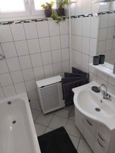 a white bathroom with a sink and a tub at Apartment Balatonszarszo/Balaton 20083 in Balatonszárszó