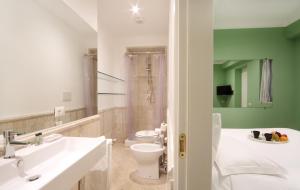 ローマにあるザ ワン プラティ ルームスのバスルーム(白い洗面台、トイレ付)