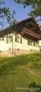 捷克克魯姆洛夫的住宿－Vila Hesha，一座带绿色窗户和草地的建筑