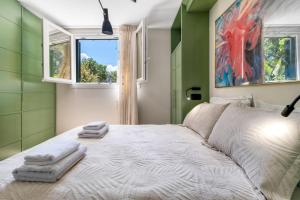 a bedroom with a large bed with towels on it at Polys Villa Lefkada 1 in Lefkada Town +37 photos