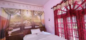 een slaapkamer met een bed en een raam bij JJ's White House in Trichūr