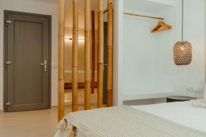 a bedroom with a bed and a door to a bathroom at Avanti in Ios Chora