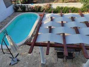 - une piscine avec une table et des chaises à côté dans l'établissement Joy I, à Šibenik