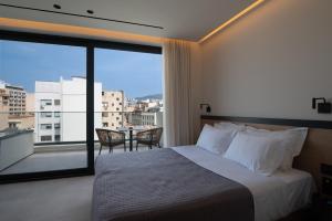 a hotel room with a bed and a large window at Nema Hotel Athens in Athens
