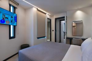 a bedroom with a white bed and some windows at Nema Hotel Athens in Athens