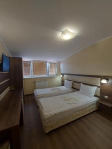 sypialnia z 2 łóżkami i telewizorem z płaskim ekranem w obiekcie Elegant Complex w mieście Pazardżik
