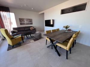 Villa Resort Apartments by Hiekka Booking في كالايوكي: غرفة طعام مع طاولة وكراسي وأريكة